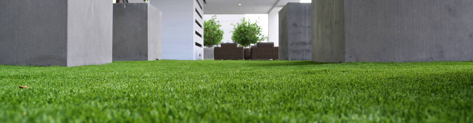 Southwest Greens lawn turf grass installed between modern concrete columns leading to a contemporary outdoor patio seating area.